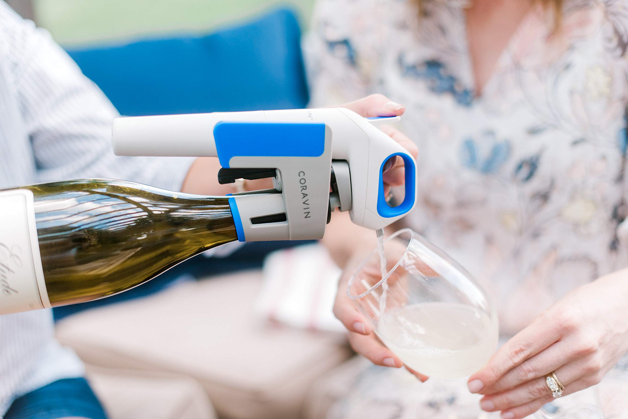 Mise en service d’un système de conservation du vin au verre : extraction et service d’un vin blanc dans un verre, avec un appareil bleu et blanc en action. Quels systèmes de conservation du vin au verre les restaurants et bars à vin utilisent ils ?